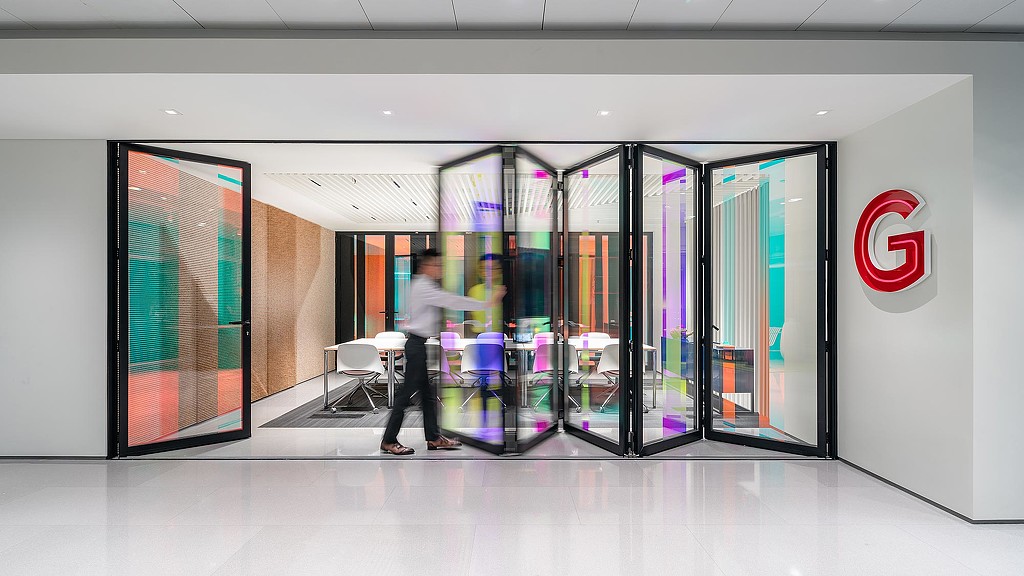 A person standing in front of a glass door.